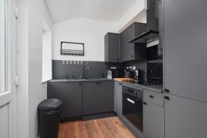 a kitchen with black cabinets and a sink at Victoria House in Leeds