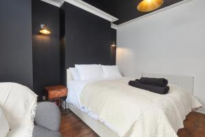 a bedroom with a white bed and a chair at Victoria House in Leeds