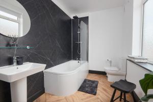 a bathroom with a tub and a sink and a toilet at Victoria House in Leeds