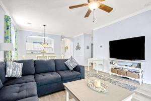Barefoot Resort في ميرتل بيتش: غرفة معيشة مع أريكة زرقاء وتلفزيون بشاشة مسطحة