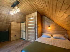 um quarto com uma cama grande e um tecto em madeira em Chëcz u Wéłka em Borsk