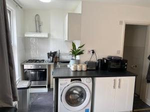 a kitchen with a washer and a washing machine at Luxury 1Bed Holiday Flat-10 Minutes from London Bridge & 3Mins walk to Lewisham DLR in London