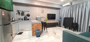 a kitchen with a counter and a tv in a room at 1-5Pax Bayu Beach SEAFRONT,POOL,STEAMBOAT,BBQ in Port Dickson