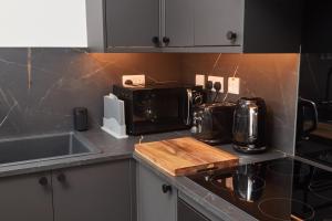 a kitchen with a counter top with a microwave at Victoria House in Leeds +6 photos