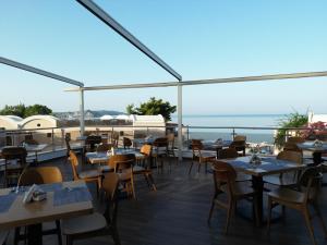a restaurant with tables and chairs and a view of the ocean at Olympion Sunset Halkidiki in Fourka