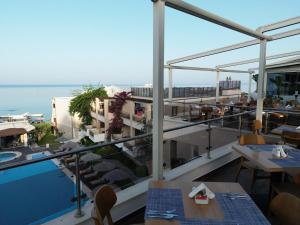 a balcony with tables and a view of the ocean at Olympion Sunset Halkidiki in Fourka