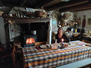 a woman sitting at a table with a candle at Cascina Gervasoni in Madonna della Costa