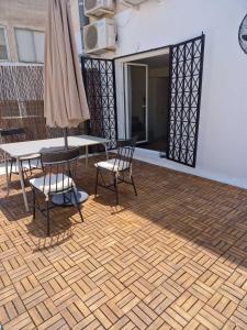 une terrasse avec une table, des chaises et un parasol dans l'établissement Ermou studio apartment, à Athènes