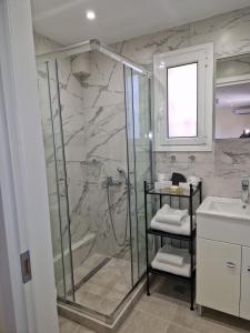 La salle de bains est pourvue d'une douche et d'un lavabo. dans l'établissement Ermou studio apartment, à Athènes