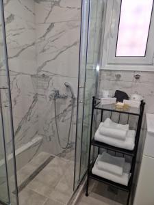 La salle de bains est pourvue d'une douche, d'un lavabo et de serviettes. dans l'établissement Ermou studio apartment, à Athènes