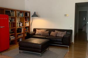 a living room with a leather couch and a ottoman at Apartamento en el Centro in Seville