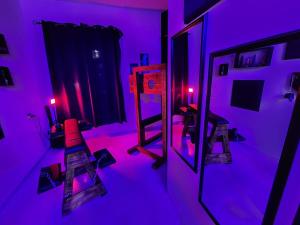 a room with purple lights and a room with a refrigerator at Taboo21+ in Ashkelon