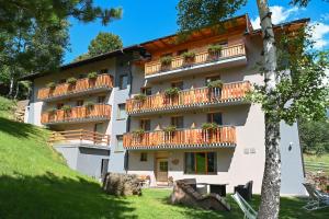 un edificio con balcones y plantas. en Albergo Sporting, en Peio Fonti