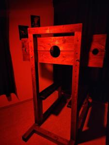 a wooden stool in a room with red light at Taboo21+ in Ashkelon