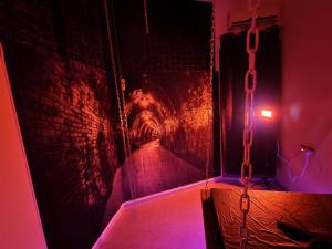 a dark room with a brick wall and purple lights at Taboo21+ in Ashkelon