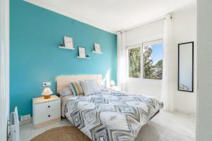 Dormitorio azul con cama y ventana en Coastal Paradise & Cozy Home with a 150m from the Beach!, en Cambrils