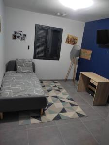 Schlafzimmer mit einem Bett, einem Tisch und einem TV in der Unterkunft Villa 110m2, 3 chambres, piscine. in Uchaud