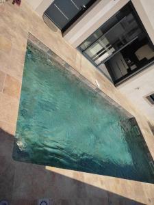 a pool of water in the middle of a building at Villa 110m2, 3 chambres, piscine. in Uchaud