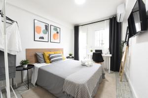 a white bedroom with a bed and a window at Nordik Apartments Village - Arroyo "Rovaniemi" in Benalmádena