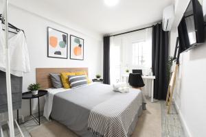 biała sypialnia z łóżkiem i oknem w obiekcie Nordik Apartments Village - Arroyo "Rovaniemi" w mieście Benalmádena