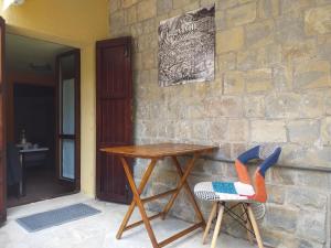 a wooden table and two chairs next to a stone wall at B&B CINGVLVM in Cingoli