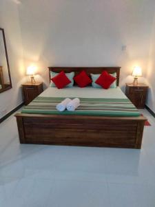 a bedroom with a large bed with red pillows at Cozy Homestay Kandy in Kandy