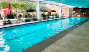 una gran piscina azul en un edificio en Casa Vive Grand by Kukun, en Ciudad de México