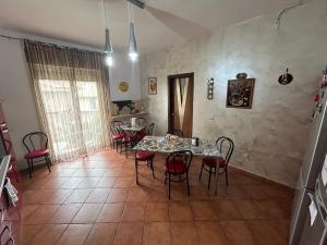 a dining room with a table and red chairs at Bed and Breakfast Soleil in Caltanissetta