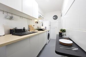 cocina blanca con encimera y fregadero en Nordik Apartments Village - Arroyo "Rovaniemi" en Benalmádena