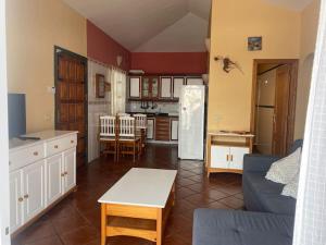 Il comprend un salon avec un canapé bleu et une cuisine. dans l'établissement Casa barbacoa, patio en la playa, à Santa Cruz de Tenerife