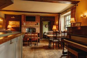 a living room with a piano and a dining room at Wheatacre White Lion in Burgh Saint Peter
