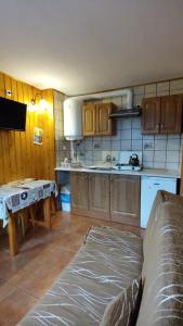 a kitchen with wooden cabinets and a couch in a room at Domki Żaklin in Berezka