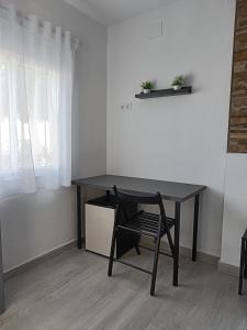 a black desk with a chair in a room at Alojamientos La Menúa in Los Badalejos