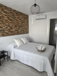 a bedroom with a bed and a brick wall at Alojamientos La Menúa in Los Badalejos