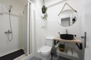 biała łazienka z toaletą i lustrem w obiekcie Nordik Apartments Village - Arroyo "Rovaniemi" w mieście Benalmádena