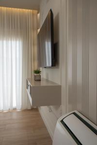 a room with a tv on a wall with a table at Comfort Apartament 27 in Durrës