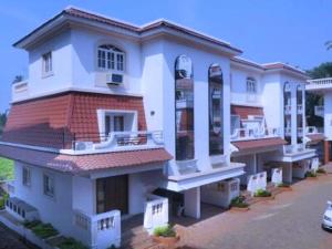 uma grande casa branca com um carro estacionado em frente em Beach ColvaPearl Luxury 3 BHK Villa em Colvá