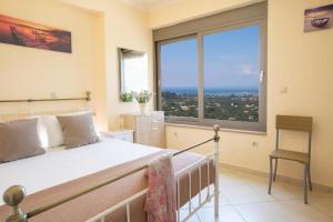 ein Schlafzimmer mit einem Bett und einem großen Fenster in der Unterkunft Silencio Villas in Lefkada Town