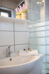 ein Badezimmer mit einem Waschbecken, einem Spiegel und Handtüchern in der Unterkunft Silencio Villas in Lefkada Town