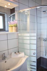 a bathroom with a sink and a glass shower at Silencio Villas in Lefkada Town