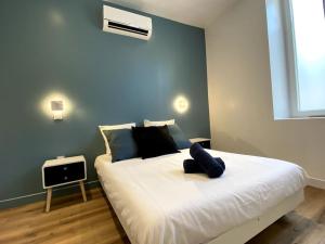 a bedroom with a large bed with a blue wall at LA PERLE BLEUE, Centre ville Valence,Proche gare in Valence