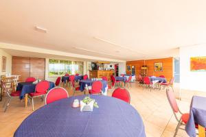 uma sala de jantar com mesas azuis e cadeiras vermelhas em Oceana Suites Eurovista em Viña del Mar