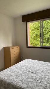 - une chambre avec un lit, une commode et une fenêtre dans l'établissement Casa Areabrava playa, à Pontevedra