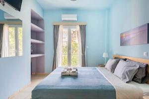um quarto azul com uma cama grande com duas almofadas em Seaside escape apartment em Palaiá Fókaia