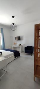 una camera bianca con un letto e una sedia di Manzoni 159 a Napoli