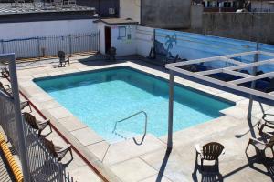 a swimming pool on a building with chairs around it at Hotel La Quinta Bonita in Ensenada