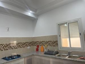 a kitchen with a sink and a window at Deluxe apartment in Kelibia