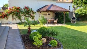 a garden with a gazebo and a table at Apartments am Saalebogen mit Gartenterrasse & Grillkamin, freie Parkplätze in Rudolstadt