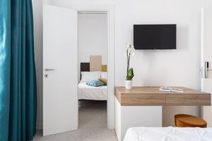 um quarto com uma secretária e uma televisão na parede em Nimar Suite em Formia