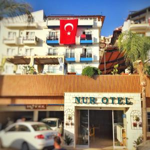 a white car is parked in front of a niveo store at Nur Hotel in Kaş